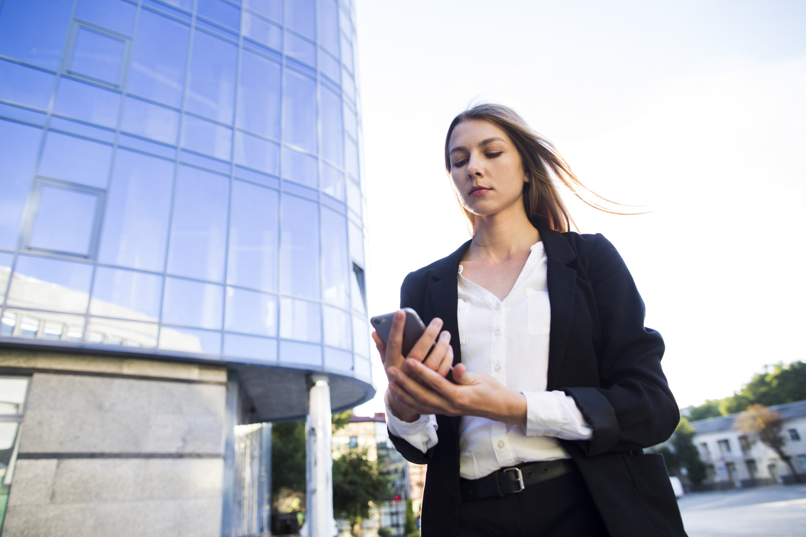 angulo-bajo-tiro-mujer-usando-un-telefono angulo-bajo-tiro-mujer-usando-un-telefono
