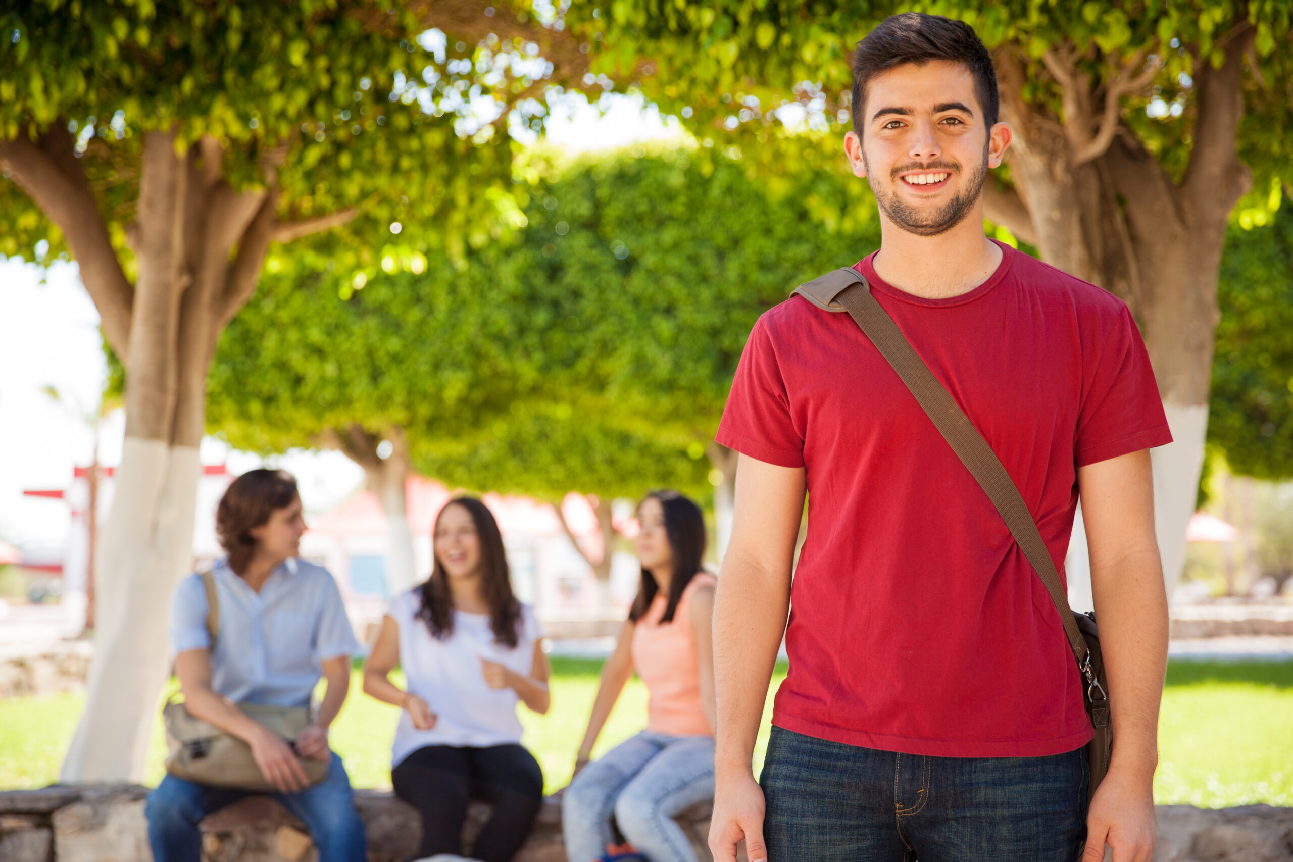 Hispanic college student smiling Handsome Hispanic young man with a school bag hanging out at the university