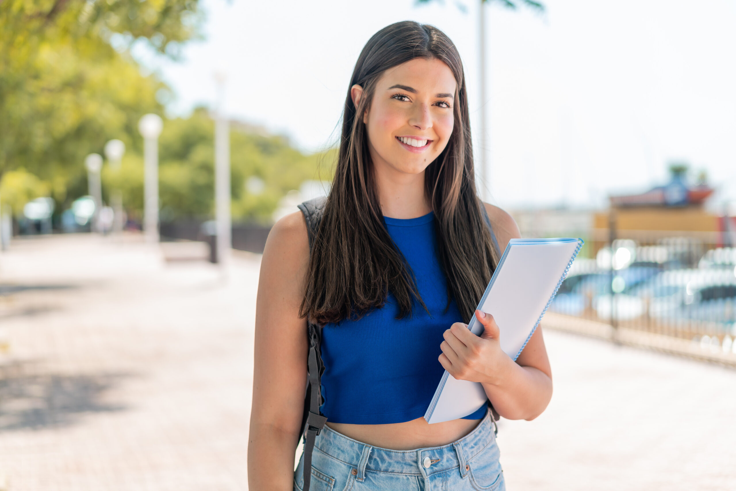 Young Brazilian student woman at outdoors smiling a lot Young Brazilian student woman at outdoors smiling a lot